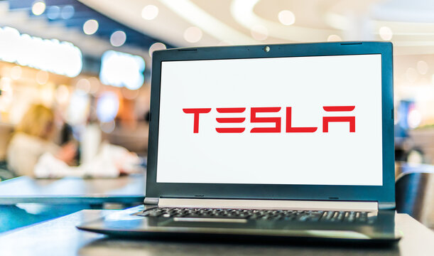 Laptop computer displaying logo of Tesla