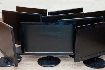Black, old, dusty, computer monitors in a pile. Computer junk.