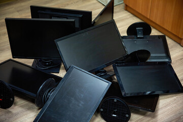 Black, old, dusty, computer monitors in a pile. Computer junk.