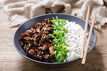 plate of  teriyaki beef, rice, green onion and sesame seeds