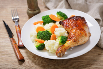 plate of baked chicken leg with vegetables