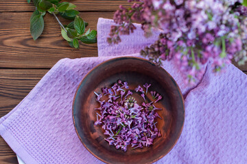 a bouquet of lilacs in a vase on a wooden background. drying of flowers for the production of fragrant oil