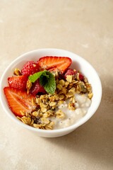 Oatmeal porridge with strawberry, homemade granola. Healthy breakfast.