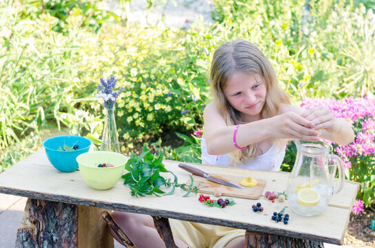 child preparing fresh juicy drink in colorful garden for the garden outdoor party