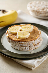 Rice cake with banana and peanut butter, healthy protein snack.