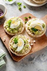 Avocado tuna salad on rice cakes with red onions and boiled egg. 