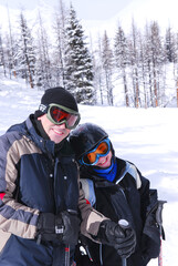 Fototapeta na wymiar Father and daughter enjoying downhill skiing in winter mountains