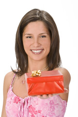 Young brunette offering a red gift box with a bow. Selective focus on the model's face.Shot with Canon 70-200mm f/2.8L IS USM