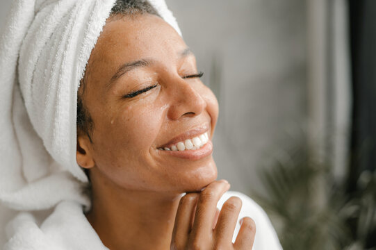 Happy black female smiling with closed eyes after bath
