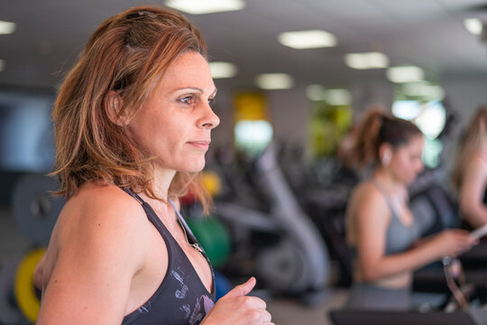 Adult Woman Running On A Treadmill In Health Club. Healthy Lifestyle