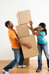 African American female placing boxes on large stack man is holding.