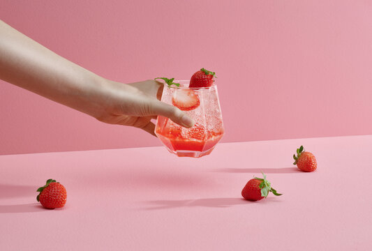 Young woman hands holding freshly squeezed strawberry lemonade