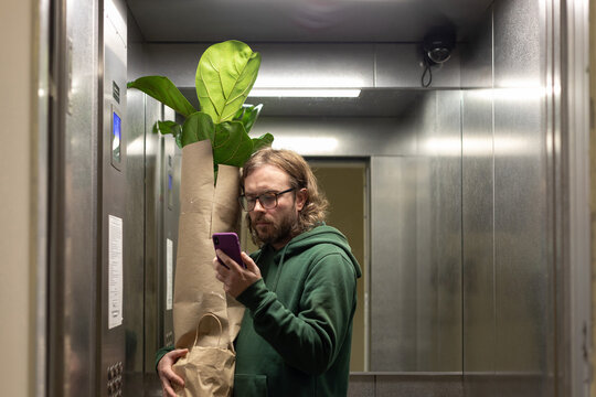 man looking at phone in elevator