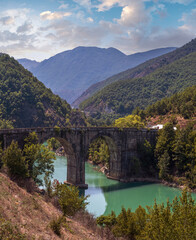 Fototapeta na wymiar Ura e Ulzes bridge on one of most beautiful roads in Albania along the Shkopet Lake precipitous сoast. Lake Ulza Nature Park, Diber County, Balkan mountains, Albania, Europe.