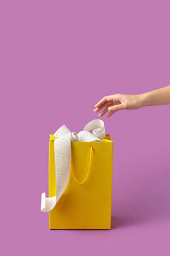 Pay receipts in shopping bag with reaching hand.
