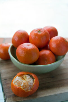 group of Tangerines in a ceramic blue bowl on a counter