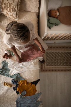 Baby sleeping while mother folding clothes