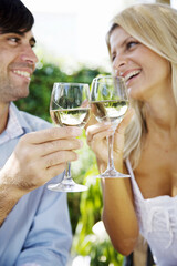 young couple enjoying a glass of white wine in the garden on a summer day
