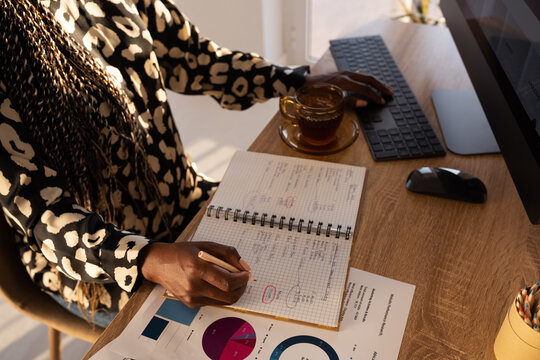 Crop female freelancer working with charts