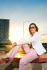 Portrait of young business woman sitting outdoors at sunset