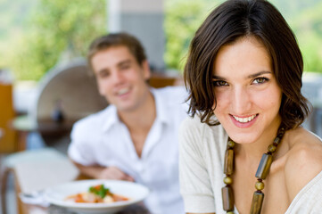 A young couple on vacation eating lunch at a relaxed outdoor restaurant