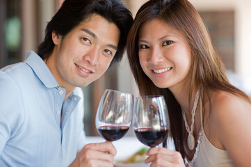 A young couple with red wine at a restaurant