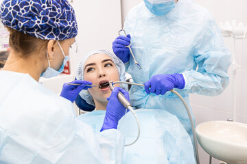 Dentistry concept. Professional dental services and modern equipment without pain. A doctor with an assistant treats the patient's teeth and gives an anesthetic injection