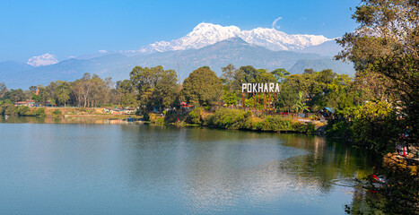 Pokhara sign, at lake in Nepal with himalaya in background