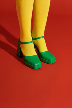 Legs of young woman in socks and shoes on color background