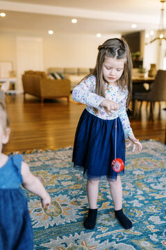 little girl playing with her yoyo at home
