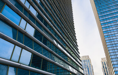 Fototapeta premium The geometry of modern urban architecture is reflected in the glass facades of buildings