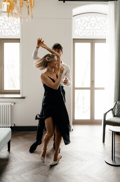 Graceful ballerina dancing with partner in hotel
