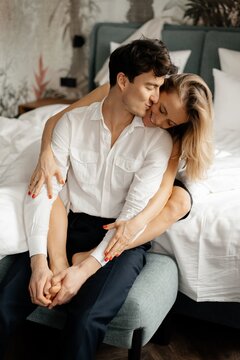 Calm man kissing girlfriend on comfortable bed
