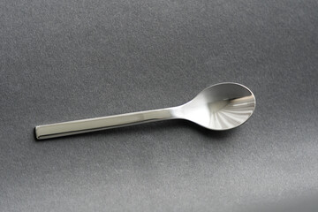 Close-up top view of stainless steel espresso spoon against black background. Photo taken May 16th, 2023, Zurich, Switzerland.