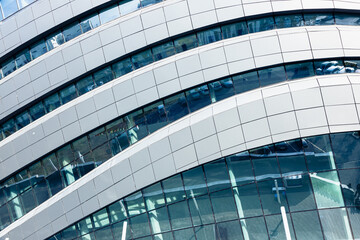 Obraz premium The geometry of modern urban architecture is reflected in the glass facades of buildings