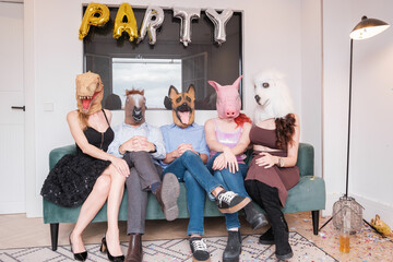 Group of people sitting on the sofa with animal masks. Concept: lifestyle, animals, wild