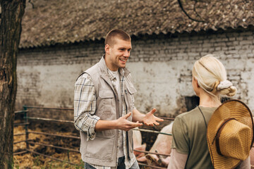 A Caucasian man talks excitedly to a blond woman at the farm.