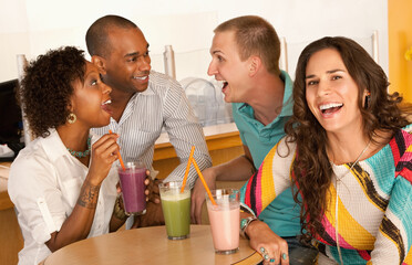 Two couples at a cafe drinking frozen beverages. Horizontal shot.