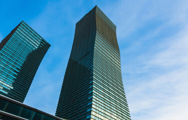 Obraz premium The geometry of modern urban architecture is reflected in the glass facades of buildings