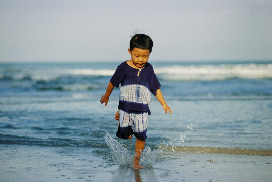 Asian boy playing with waves