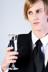Young blonde male holding full Champaign glass