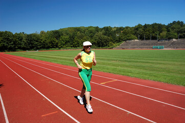 Fototapeta na wymiar Active senior woman jogging in a stadium