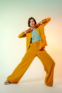 Trendy female model dancing in yellow outfit