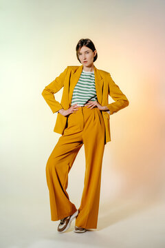 Brunette woman in yellow suit with hands on waist