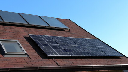 The roof of the house with thermosolar and photovoltaic panels. Self-sufficient house. Green energy. Green deal.