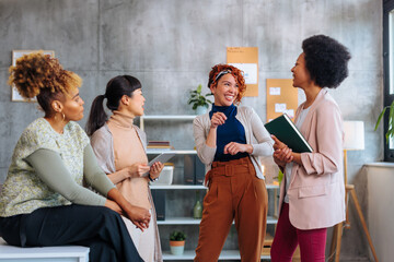 Startup business team of three young women joking together.