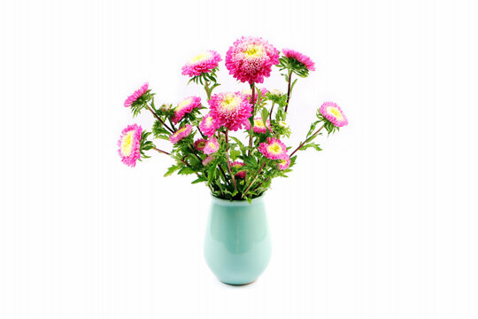 Vase of pink and yellow flowers isolated on white.