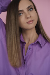 Portrait of a young woman with blue eyes and straight brown hair wearing t-shirt of purple color - 603086229