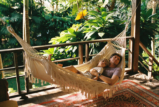 Father resting with a daughter in a hammock