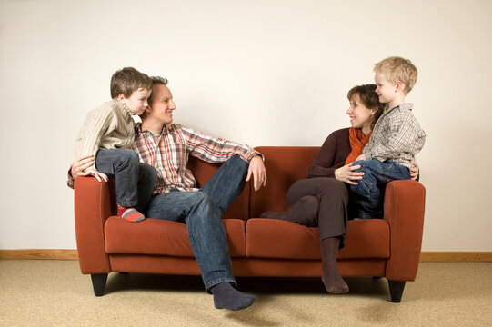 Nice family picture, sitting together on a couch.